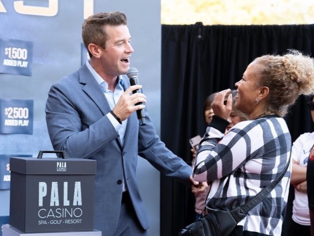 Joe Cummings hosting a brand activation game show on stage for Pala Casino with a microphone