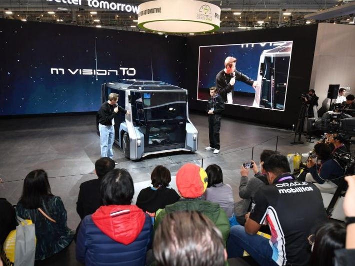 Joe Cummings presenting the Hyundai M.Vision TO concept vehicle on stage at CES in front of a trade show crowd